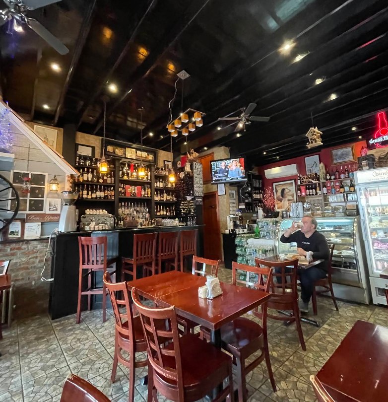 Warm, intimate interior of Parisienne Cafe with wooden tables and soft lighting